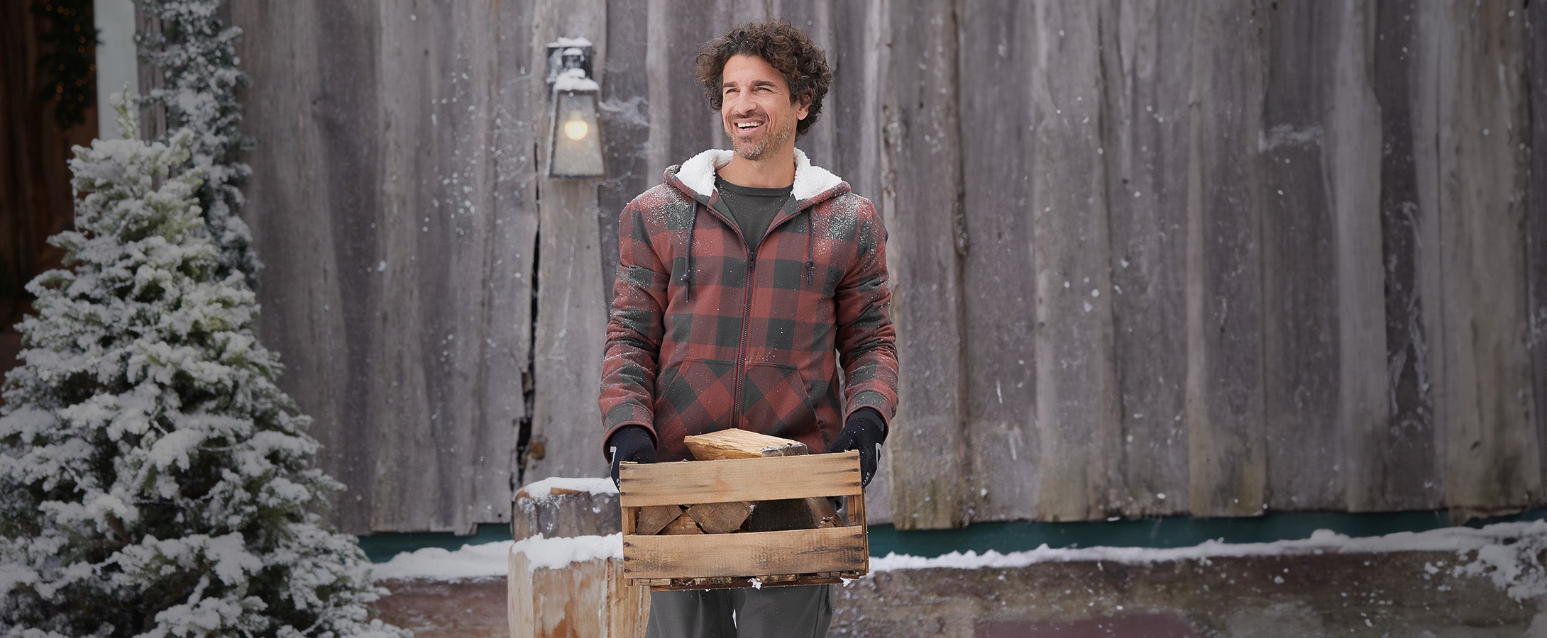 Man wearing the check-hooded jacket from the e.s. Iconic collection in a winter setting